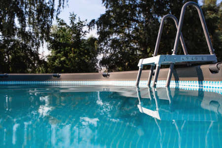 Swimming pool with metal frame for home and garden. Frame swimming pool in the yard. Solar banner.Installation of the pool. The concept of summer holidays and recreation.の写真素材