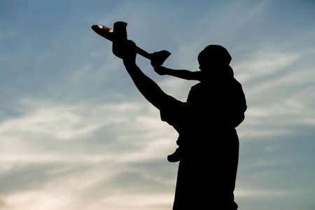 Father and son launch a toy airplane at sunset. Silhouettes of people against the sky. The concept of a friendly family and Father's Day. air tour. Go on a trip, a flight and a vacの写真素材