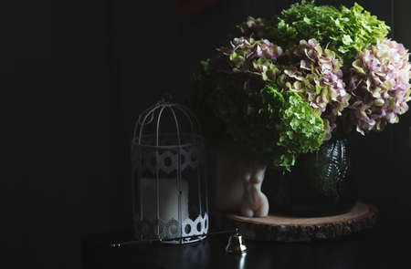 A bouquet of green and pink hydrangeas and candles. Interior in Provence style. A concept for a flower shop or home comfort and decor in the house.の写真素材