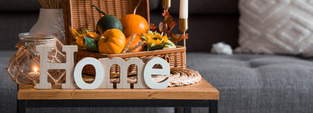 Cozy autumn concept. Home warmth in cold weather. still life. Pumpkins, wicker basket, candles and...