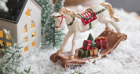 Happy New Year 2023. A Christmas card, a banner with a rocking horse, Christmas trees, gifts and a beautiful bokeh in the background. The concept of home winter holidays, warmth anの写真素材
