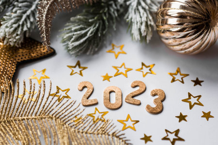 Banner. Happy New Year. Golden numbers 2023, fir branches, Christmas tree toys and golden stars on a white background. flat lay.の写真素材