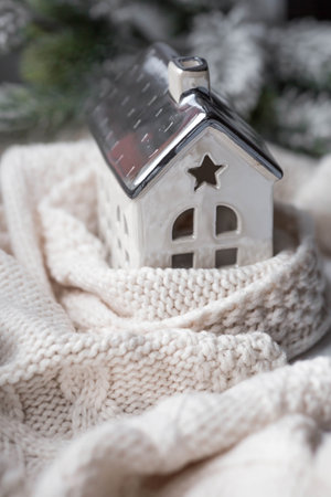 A house wrapped in a scarf. Winter. Home insulation, protection from cold and bad weather, room heating system. The energy crisis in Europe. Festive mood, Christmas, New Year 2023の写真素材