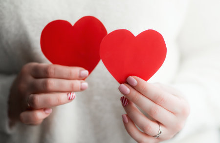 Two red hearts in the hands of a woman.The concept of the celebration. Happy Valentine's day.の写真素材