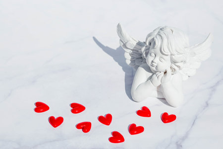 Cute angel, hearts on a white marble background. Theme of love. Valentine's day. Postcard for the...