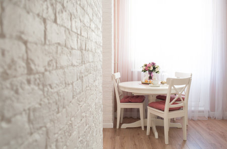 Scandinavian style of interior.Golden easter eggs, unicorn eggs and white rabbits on a white wooden kitchen table. minimal concept. Card with copy space for text.の写真素材