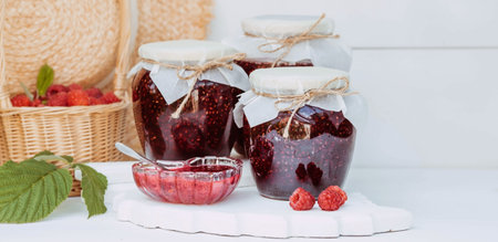 Homemade healthy jam with raspberries on a white wooden table. Treatment of colds. conservation and...