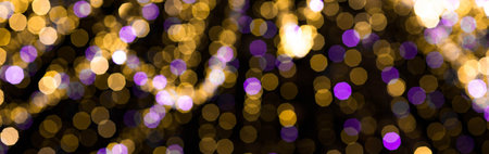 Abstract blurred bokeh light on a Christmas tree in a warm and purple shade. Beautiful New Year...