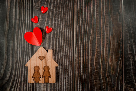 Home symbol with red hearts on wooden background with copy space. home sweet home.の写真素材