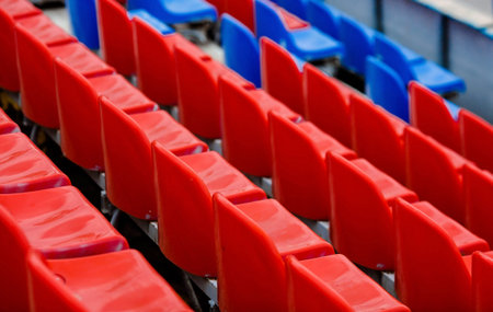 Banner. Empty seats in the stands of the arena or auditorium. Rows of red and white stadium seats...
