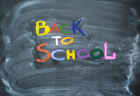 The inscription on the black slate in multi-colored letters: Black to school. Top view on a flat...
