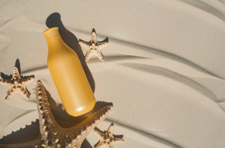 Sun protection factor and starfish on the sand. A bottle of sunscreen. The concept of sea recreation...