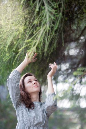 Portrait of a girl in a greenhouse. Woman admires plants.の写真素材