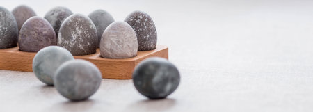 Stylish gray Easter eggs in marble and concrete on a wooden stand. Coloring eggs with natural dye karkade tea. Environmental friendliness. naturalness. The concept of happy Easter 2023.の写真素材