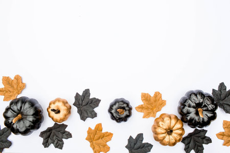 Banner. Modern background with bats, black and gold pumpkins, leaves, cobwebs, spiders on a white background. Halloween with copy space for text. Flat lay, top.の写真素材