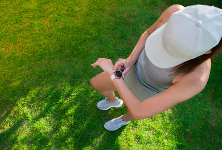 A young woman checking progress on a smart watch. A female runner looks at a smart watch heart rate monitor. Copy of the text space. The concept of sports and a healthy lifestyleの写真素材