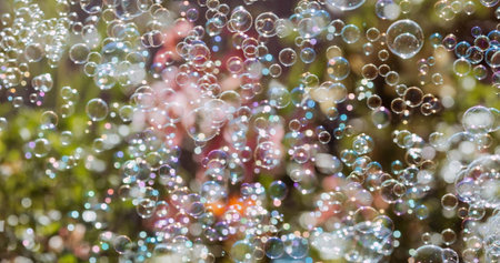 Banner. Festive background with shimmering shiny iridescent transparent soap bubbles on the green...
