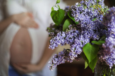 Cropped shot of a young beautiful woman in the third trimester of pregnancy and a bright bouquet of...