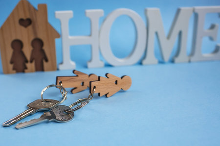 The keys to the home and the word house in blue background. Concept for real estate, moving home or renting real estate.の写真素材