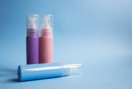 Cosmetic bottles and containers with empty labels for marking the layout on a blue background.の写真素材