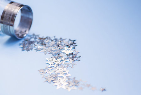 Wine glasses with silver star confetti on blue background. Flat lay, top view. Holy day and...