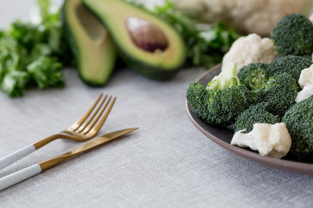 Fresh green broccoli, cauliflower and avocado on a plate on a linen tablecloth. Broccoli cabbage...