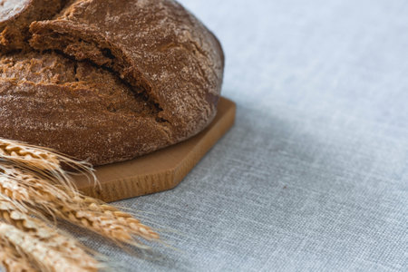 Fresh delicious bread close-up. Freshly baked sourdough bread with a golden crust on a wooden board. The context of a bakery with delicious bread. confectionery products.の写真素材