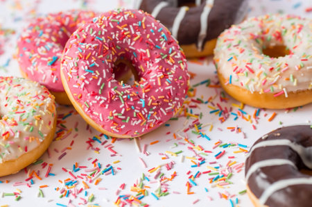Delicious dessert. Pink, white and chocolate donuts with multicolored sprinkles on a white background of Sweets. confectionery products.の写真素材