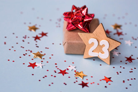 Greeting card for the Defender of the Fatherland Day. White, gold, red stars, a gift box and the number 23 on a light blue background. The holiday is February 23.の写真素材