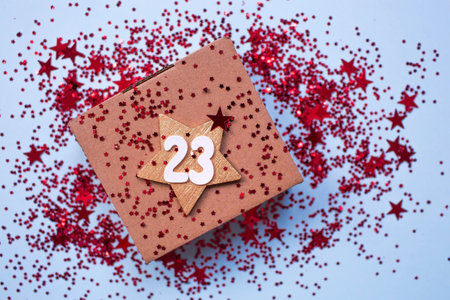 Greeting card for the Defender of the Fatherland Day. White, gold, red stars, a gift box and the number 23 on a light blue background. The holiday is February 23.の写真素材