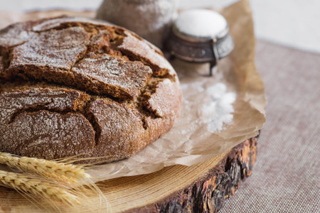 Fresh delicious bread close-up and salt. Freshly baked sourdough bread with a golden crust on a wooden board. The context of a bakery with delicious bread. confectionery products.の写真素材