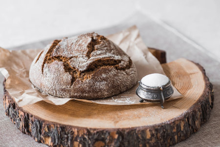 Fresh delicious bread close-up and salt. Freshly baked sourdough bread with a golden crust on a wooden board. The context of a bakery with delicious bread. confectionery products.の写真素材
