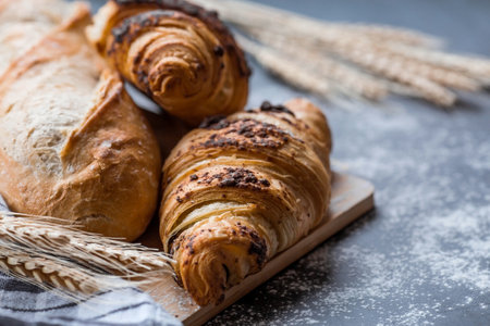 Delicious freshly baked croissants with chocolate on a dark background. french breakfast. Delicious pastries close-up. The context of a bakery with delicious bread. confectionery products.の写真素材
