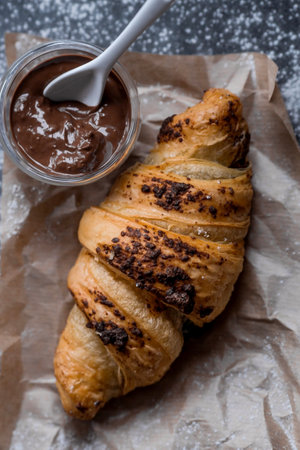 Delicious freshly baked croissants with chocolate on a dark background. french breakfast. Delicious pastries close-up. The context of a bakery with delicious bread. confectionery products.の写真素材