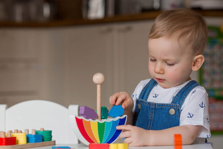 Balancing toys. A little boy is playing educational games. Children's wooden toy in the form of an...
