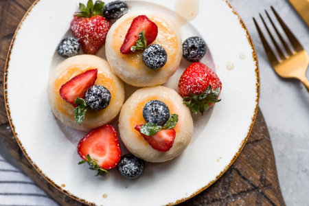 Cottage cheese pancakes, Russian cheesecakes with fresh blueberries, strawberries, honey and mint...
