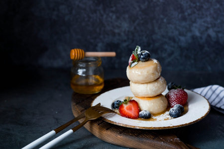 Cottage cheese pancakes, Russian cheesecakes with fresh blueberries, strawberries, honey and mint...