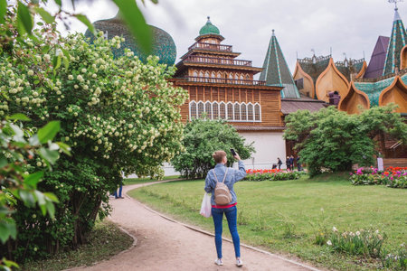 Urban landscape. A popular tourist attraction. The business card of Moscow. The wooden palace of Tsar Alexei Mikhailovich in Kolomenskoye. A tourist takes pictures of the sights. Russia, Moscow, May 2023のeditorial素材