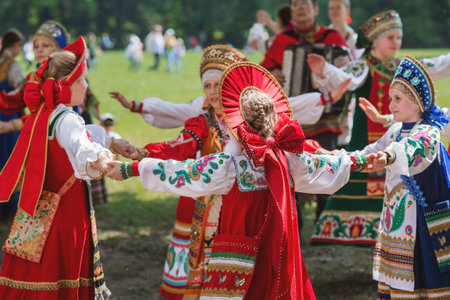 Russian folk traditions. Folk festivals. Children in beautiful Russian traditional outfits sing songs, dance and lead a round dance in Tsaritsyno Park. National Russian clothes. Sundresses and kokoshniks.のeditorial素材