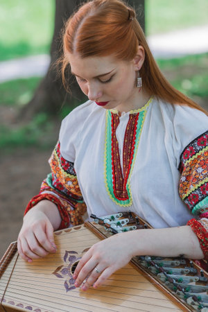 Russian folk traditions. folk festivals. A girl in a beautiful traditional Russian outfit plays the harp in Tsaritsyno Park. National Russian clothing. Sundresses and kokoshniks.のeditorial素材