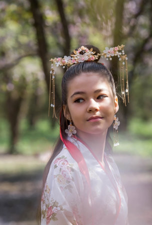 Portrait. Beautiful girl in Japanese kimano in a Japanese garden on the background of cherry blossoms. Cherry blossoms in the garden in the Biryulevsky arboretum. Russia, Tsaritsyno, 2023.のeditorial素材