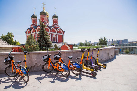 Urban transport. Parking for electric bicycles. Minute-by-minute scooter rental in the city. There are many bicycles in a row. Moscow, Russia, June 2023のeditorial素材