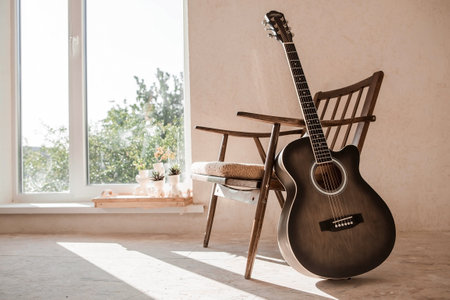 Guitar. Guitar chords. Acoustic guitar. Music. Musical background. An image of an acoustic guitar in a room with a retro armchair. Hard light. Shadows.の写真素材