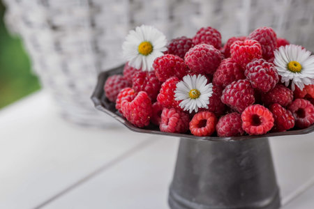 Fruits and berries. summertime. Delicious fresh raspberries on a stylish iron tray in retro style on a white table. Space for text.の写真素材