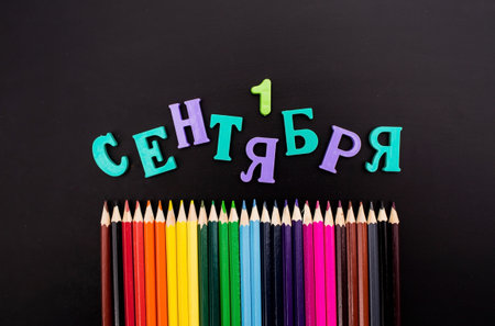The inscription of letters in Russian: "September 1" and colored pencils. Top view of flat terrain. The concept of a new school year at school. back to school. knowledge day.の写真素材