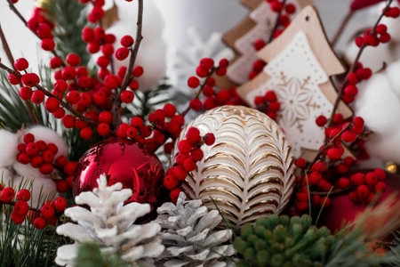 Spruce bouquet with red berries, toys and cotton close-up. Christmas decorations in the interior. The concept of preparation for the New Year holidays in 2024.の写真素材