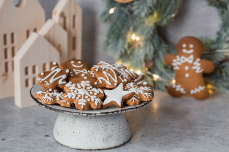 Homemade gingerbread Christmas cookies in icing sugar. Delicious gingerbread cookies on the background of a bokeh of Christmas tree lights. Freshly baked Christmas gingerbread cookies.の写真素材