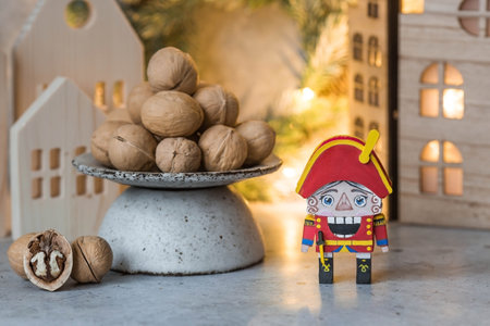 A toy soldier Nutcracker and walnuts on a Christmas background with a garland. Tchaikovsky's ballet. Christmas New Year card 2024.の写真素材