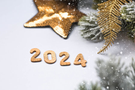 Banner. Happy New Year and Merry Christmas. Golden numbers 2024, snow, fir branches and Christmas tree toys on a white background. The flyer. Invitation.の写真素材