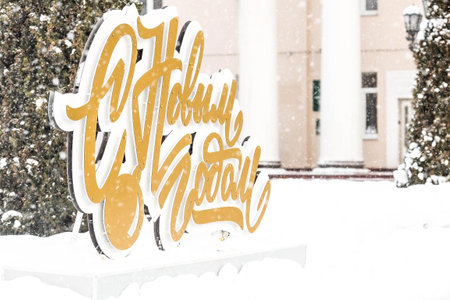 Winter. Snow is falling. Beautiful holiday decorations on the street in the city. The inscription in Russian: Happy New Year. Beautiful Christmas background. The concept of decorations and street decorations for the new year.の写真素材